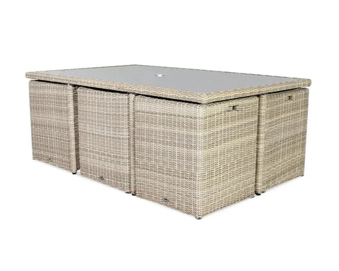 Rattan outdoor dining table with glass top and four cube stools tucked underneath