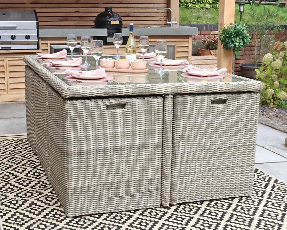 Rectangular rattan outdoor dining table with glass top set for six on patterned rug