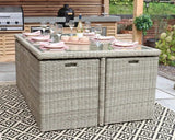 Rectangular rattan outdoor dining table with glass top set for six on patterned rug