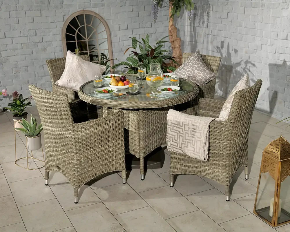 Rattan garden dining set with glass round table and four armchairs on tiled patio
