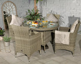 Round rattan garden dining set with glass table, four cushioned chairs, and tableware
