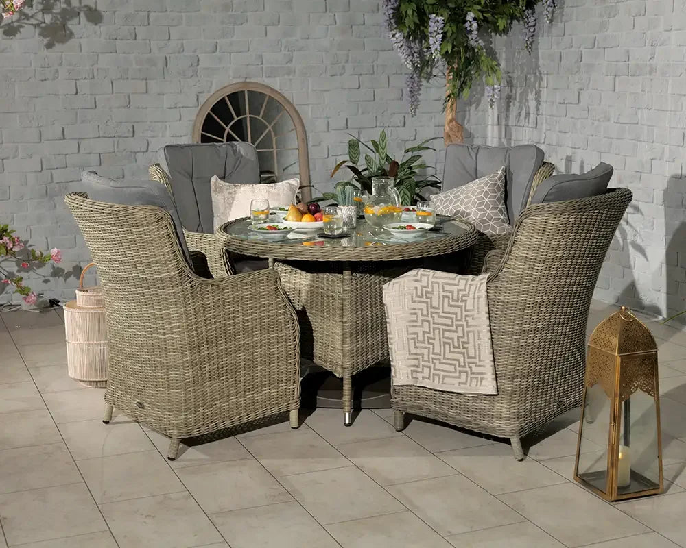 Rattan garden dining set with grey cushions and round table on tiled patio