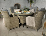 Rattan dining set with glass top table and cushioned chairs arranged for outdoor dining