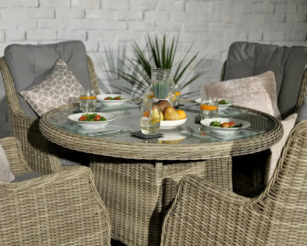 Round rattan dining set with glass top, grey cushions and place settings for four