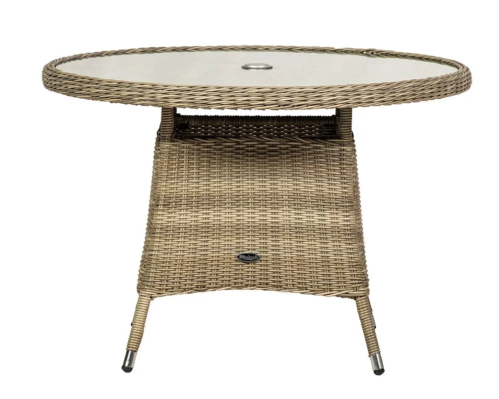 Round rattan outdoor dining table with glass top and umbrella hole, neutral tone finish