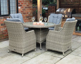 Rattan outdoor dining set with four cushioned armchairs and glass-top round table on patio