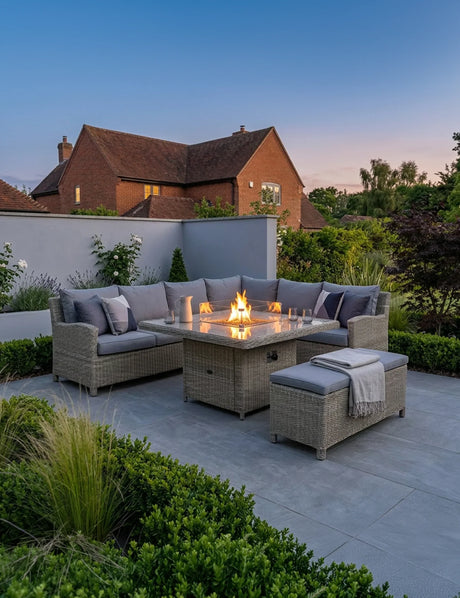 Grey rattan outdoor corner sofa set with fire pit table and bench on patio in garden