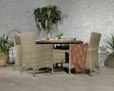 Rattan dining set with four chairs and glass table in a modern indoor setting