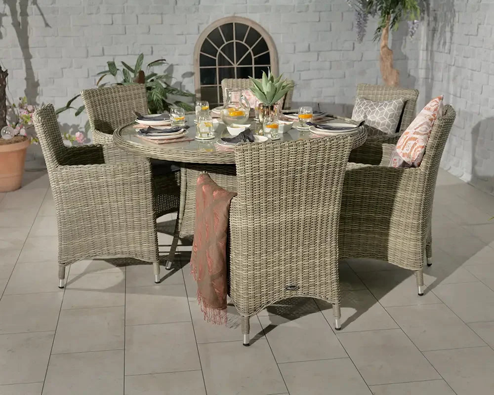 Rattan garden dining set with six chairs and glass top table on tiled patio