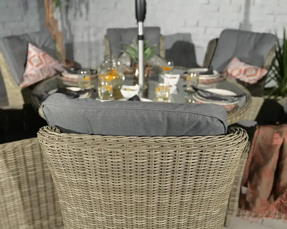 Rattan garden dining set with grey seat cushions and glass table set for outdoor meal