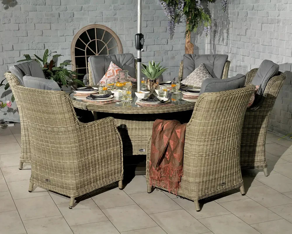 Rattan garden dining set with six cushioned chairs and glass top table arranged for outdoor meal