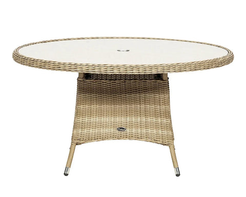 Round rattan garden table with glass top and central umbrella hole, beige wicker finish