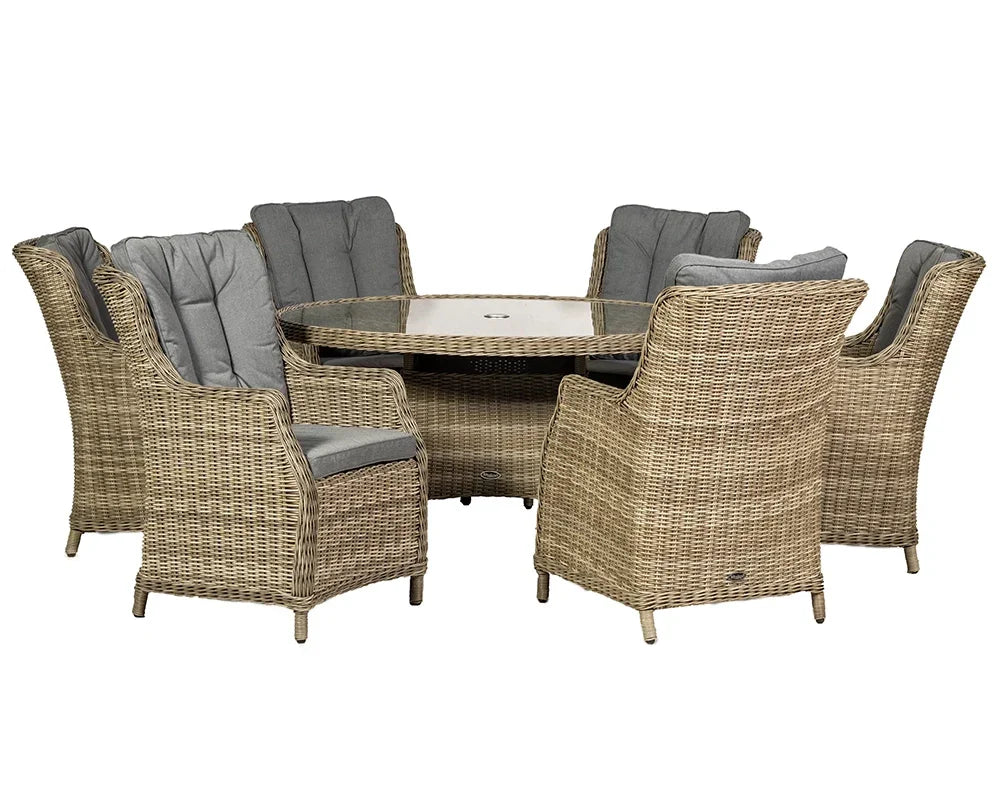Round rattan dining set with six cushioned armchairs and glass top table