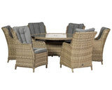 Round rattan dining set with six cushioned armchairs and glass top table