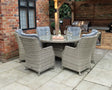Grey rattan garden dining set with six cushioned chairs and glass top table on patio