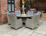 Grey rattan garden dining set with six cushioned chairs and glass top table on patio