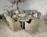 Round rattan dining set with glass table and six cushioned chairs in garden setting