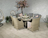 Rattan garden dining set with six cushioned chairs and glass-topped round table indoors