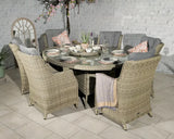 Round rattan dining set with six cushioned chairs and glass top table in indoor setting