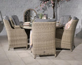 Beige rattan dining set with six cushioned chairs and round glass table, indoor setting