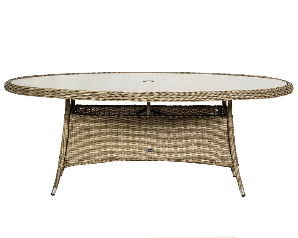 Oval rattan garden dining table with glass top and central parasol hole, front view