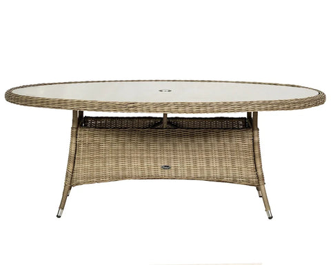 Oval rattan garden dining table with glass top and central parasol hole, front view