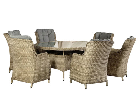 Rattan dining set with round glass table and six cushioned armchairs in natural finish