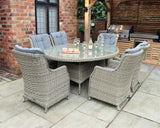 Rattan garden dining set with six cushioned chairs and glass top table on patio