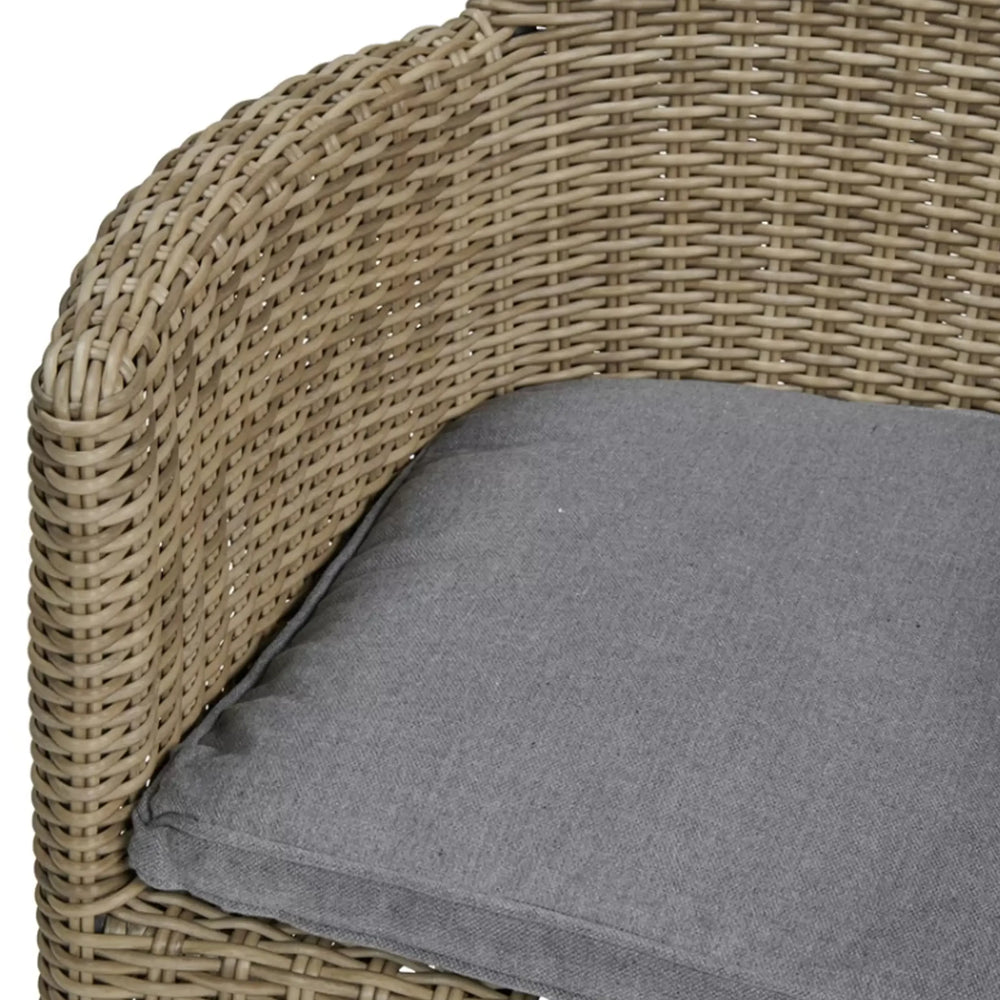 Rattan armchair with grey seat cushion, close view of wicker texture and cushion detail
