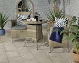 Rattan bistro set with two chairs, glass top table, grey cushions and patterned pillows