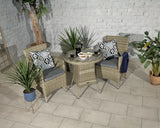 Rattan bistro set with two cushioned chairs and glass-top table arranged on tiled patio