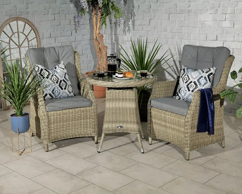 Rattan garden bistro set with two cushioned chairs, round table and decorative pillows