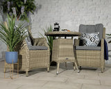 Rattan garden bistro set with two armchairs, grey cushions and round table indoors