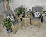 Rattan bistro set with two cushioned chairs and round glass table in indoor setting