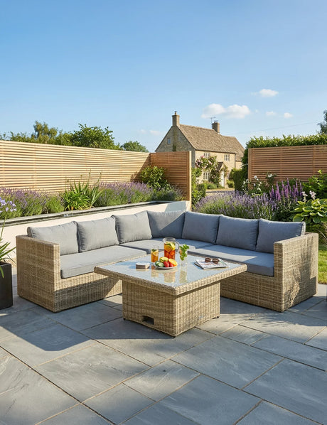 Rattan outdoor corner sofa set with grey cushions and glass top table on patio