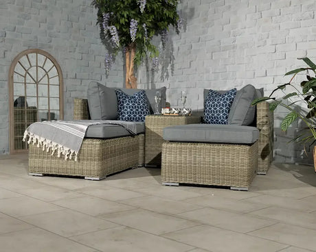 Grey rattan corner sofa set with cushions and coffee table on tiled patio