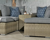 Grey rattan outdoor sofa set with blue geometric cushions and coffee table