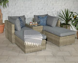 Grey rattan garden sofa set with cushions, throw and decorative pillows on tiled patio