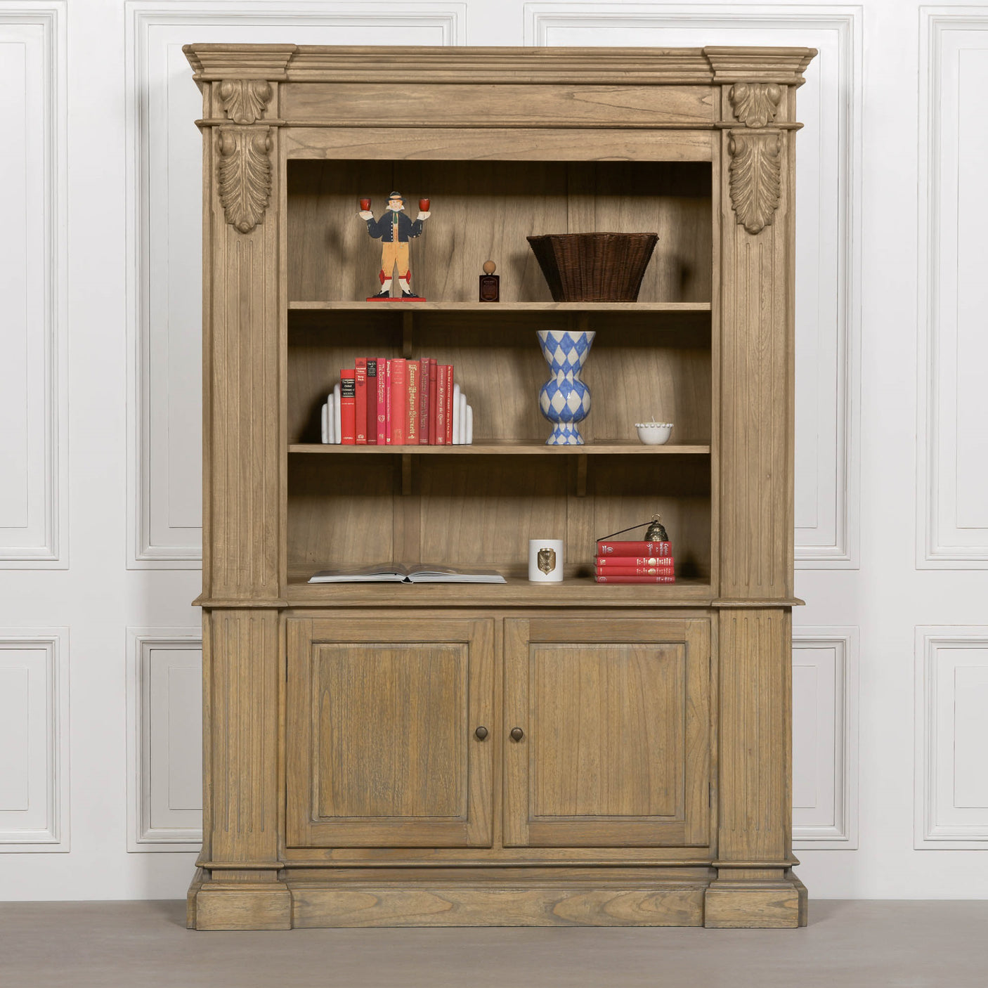 Large rustic open bookcase with decorative detailing, featuring multiple shelves and a closed cabinet at the bottom.