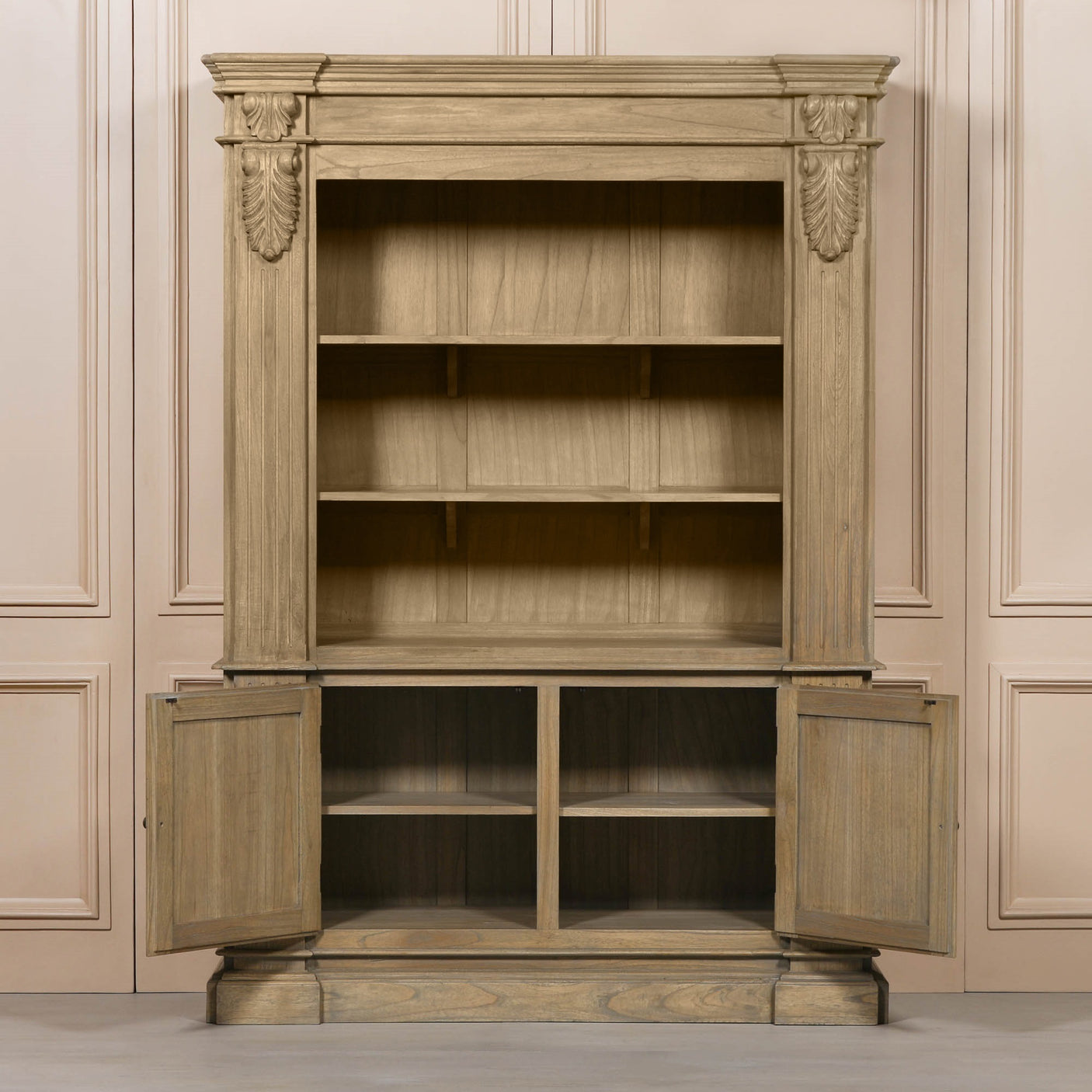 Large rustic open bookcase with decorative detailing and two lower cabinet doors.
