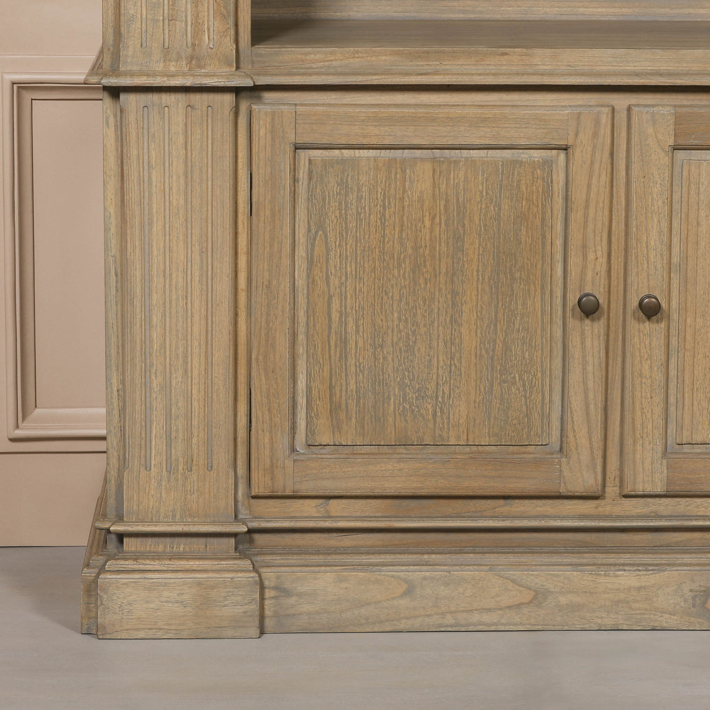 Close-up of the base of a large rustic open bookcase, featuring detailed wood grain and traditional design elements.