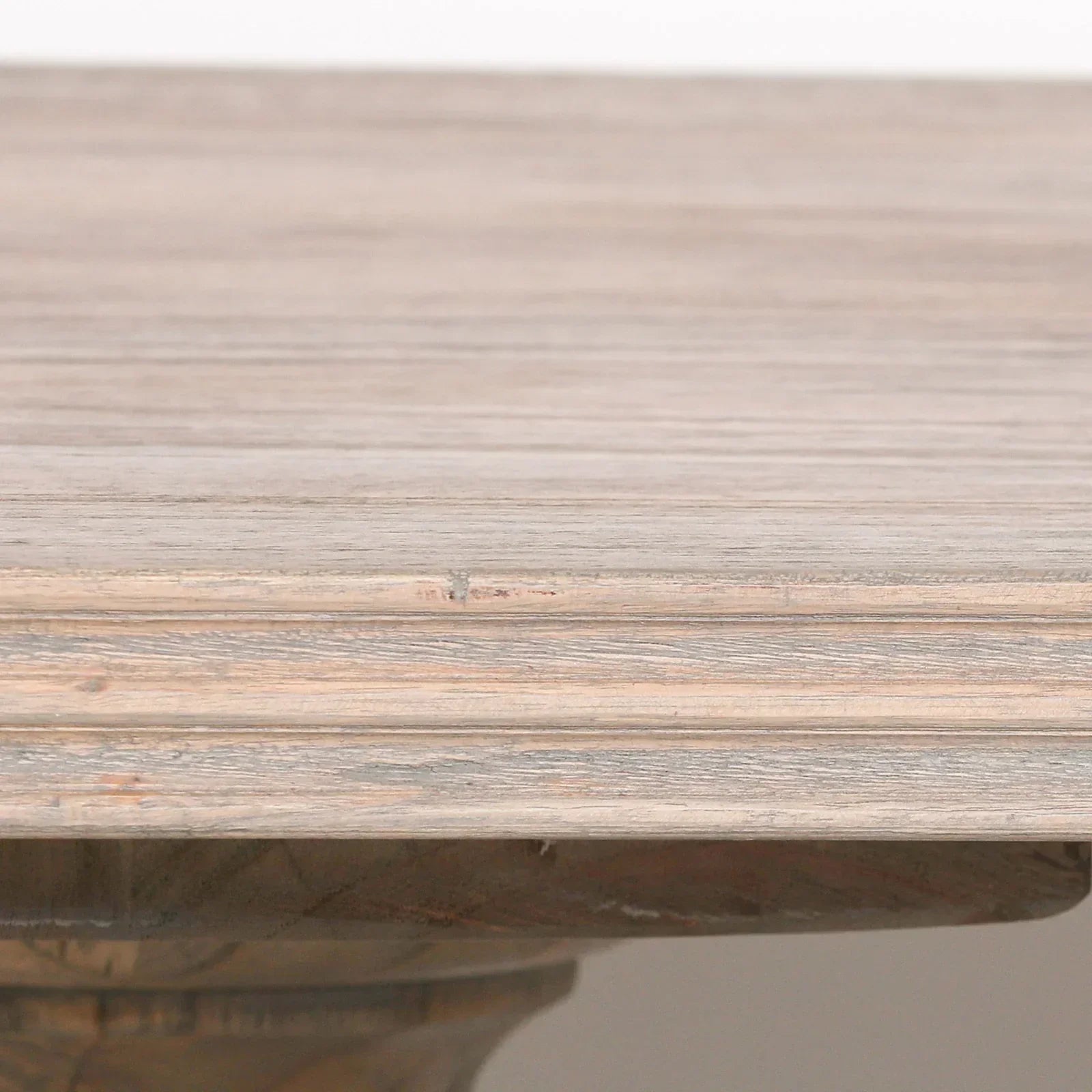 Closeup of wood dining table edge in light oak finish with textured grain detail