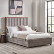 Upholstered bed in grey fabric with tall channel-tufted headboard framed in dark wood, bedding and nightstands