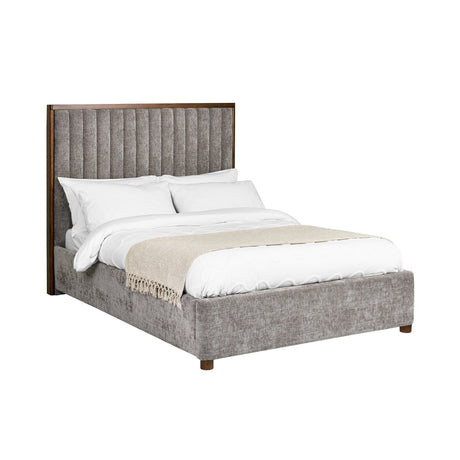 Upper corner angled view of grey fabric upholstered bed with tall channel-tufted headboard and white bedding