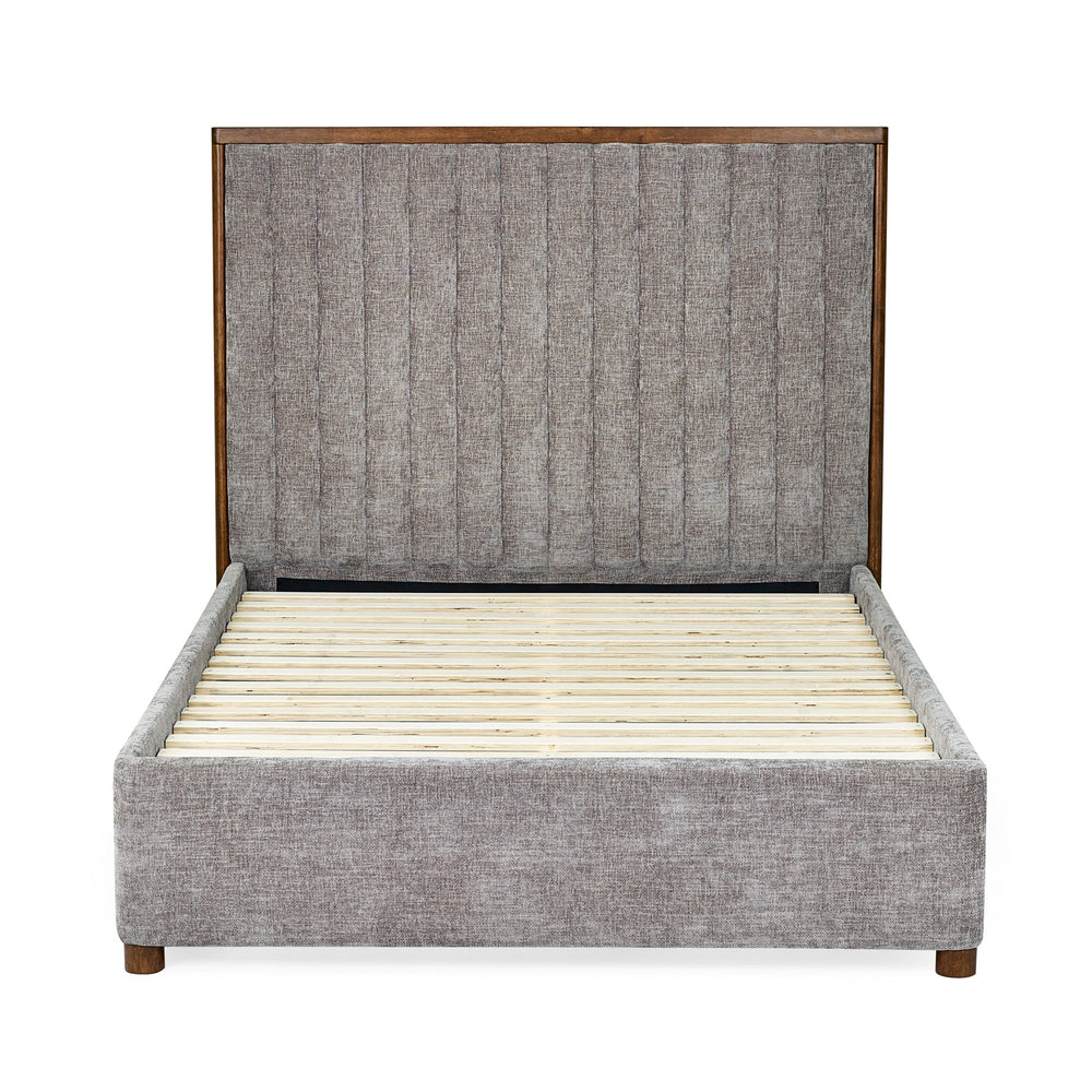 Side view of upholstered bed frame in grey fabric with wooden slats and tall channel-tufted headboard