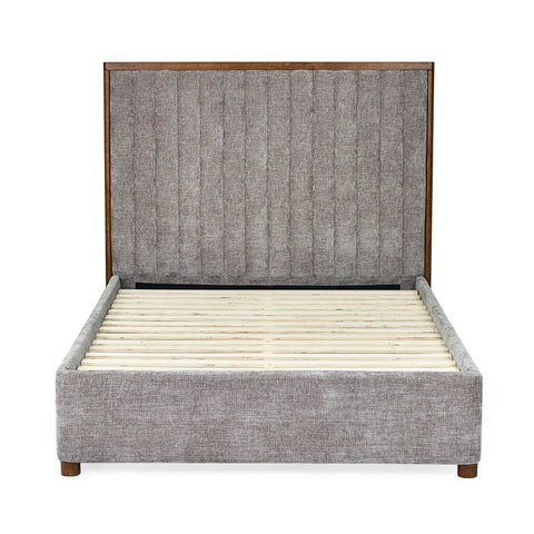 Side view of upholstered bed frame in grey fabric with wooden slats and tall channel-tufted headboard