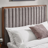 Close-up view of the rounded corner of the dark wooden frame of the bed's headboard