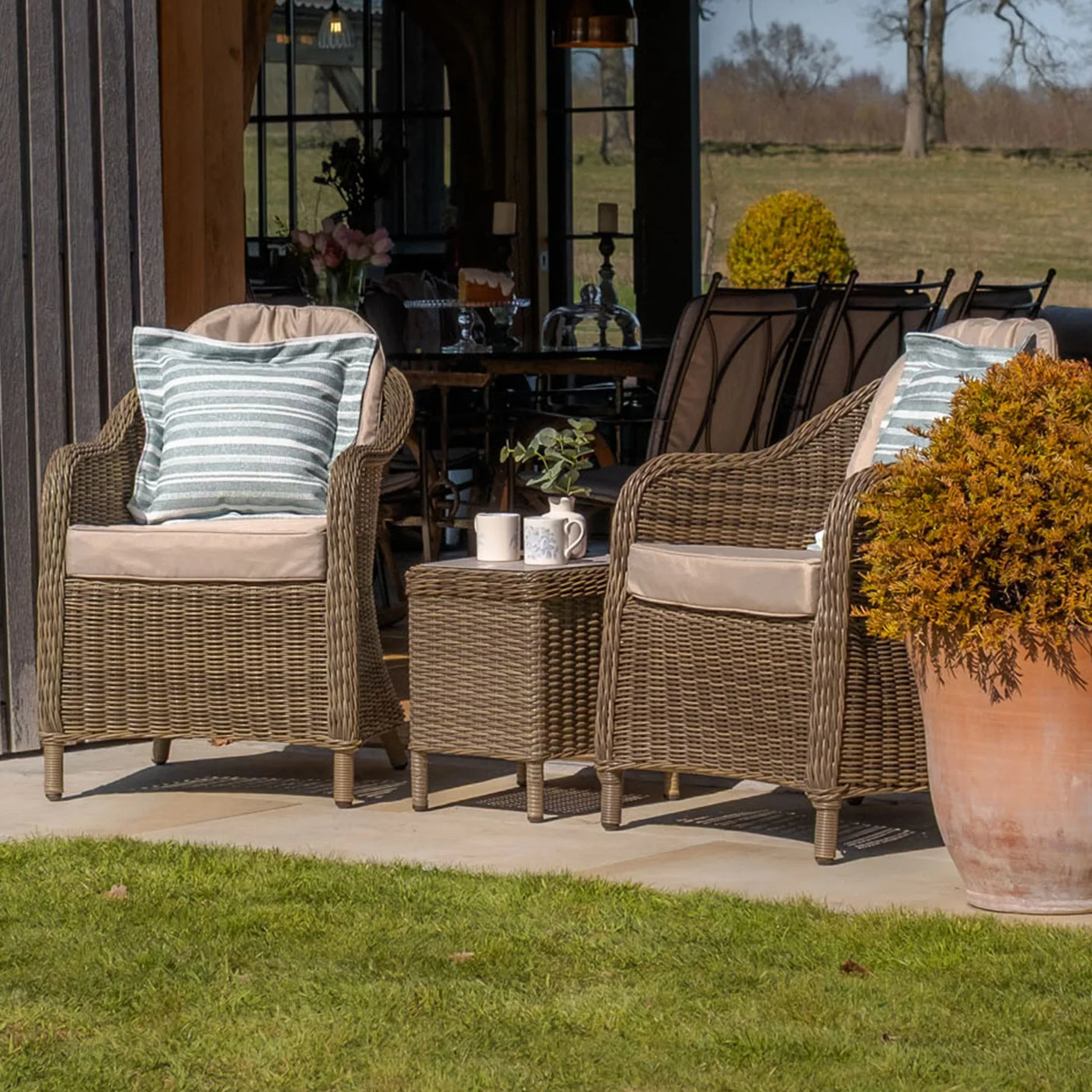 Rattan garden chair set with beige cushions and coffee table on patio