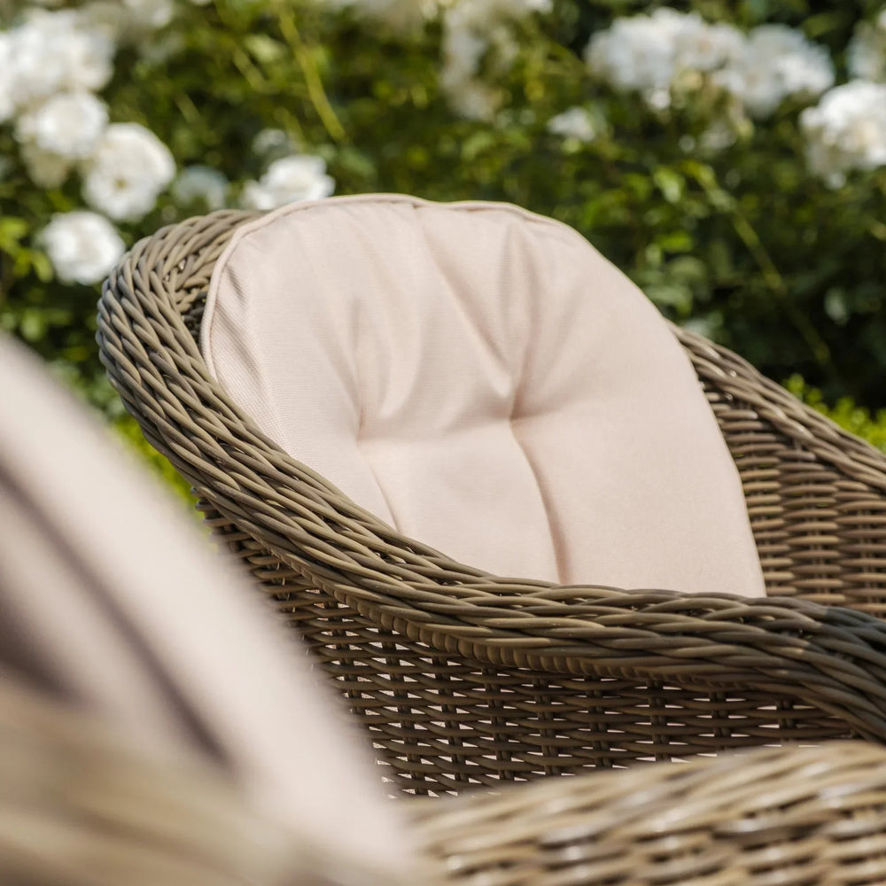 Close-up of rattan garden chair with beige cushion in outdoor setting