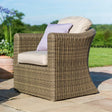 Brown rattan outdoor armchair with beige cushion and lilac pillow on patio